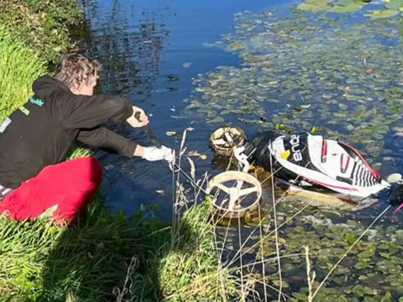 Golftrolley mit Bag im Wasserhindernis